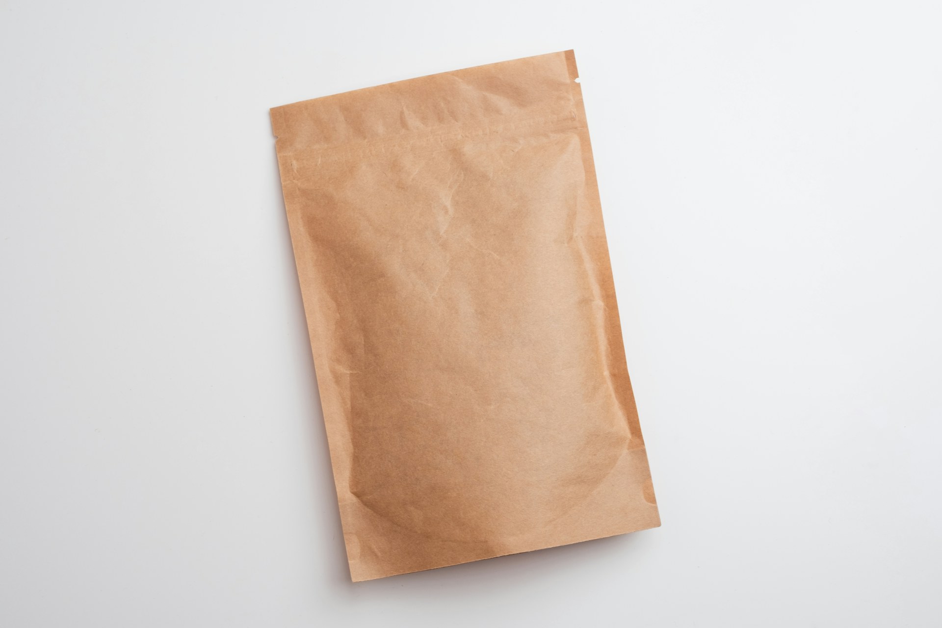 A plain kraft paper pouch on a white surface