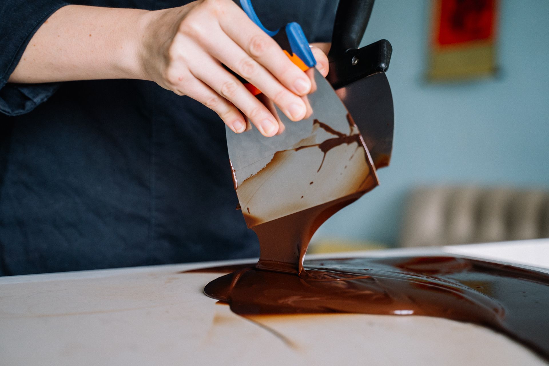 Melted chocolate being spread across a marble slab