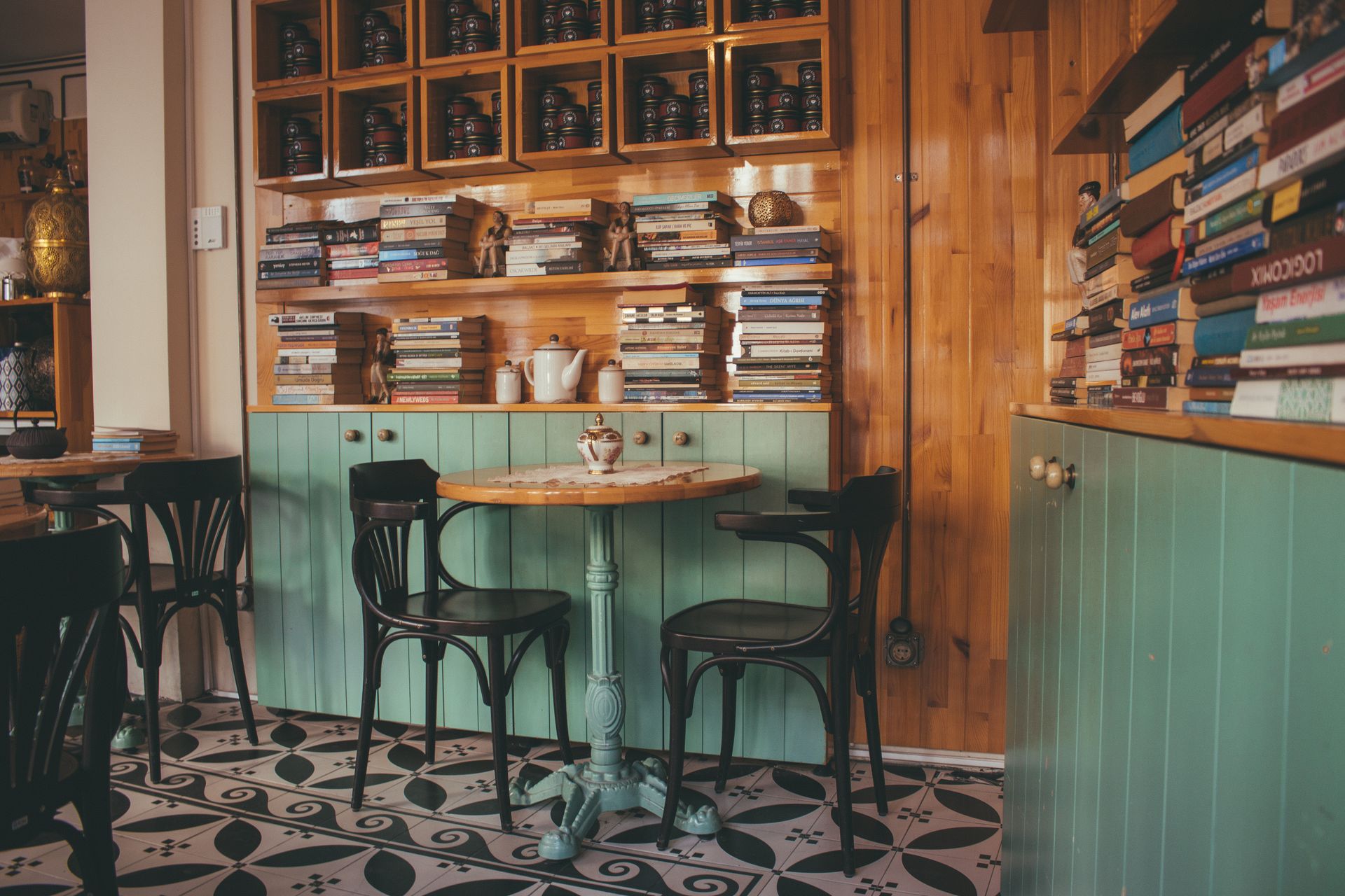 A cafe corner with shelves of books, a small round table and bentwood chairs